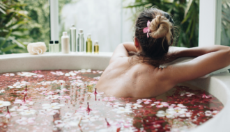 Frau in Badewanne mit Blüten