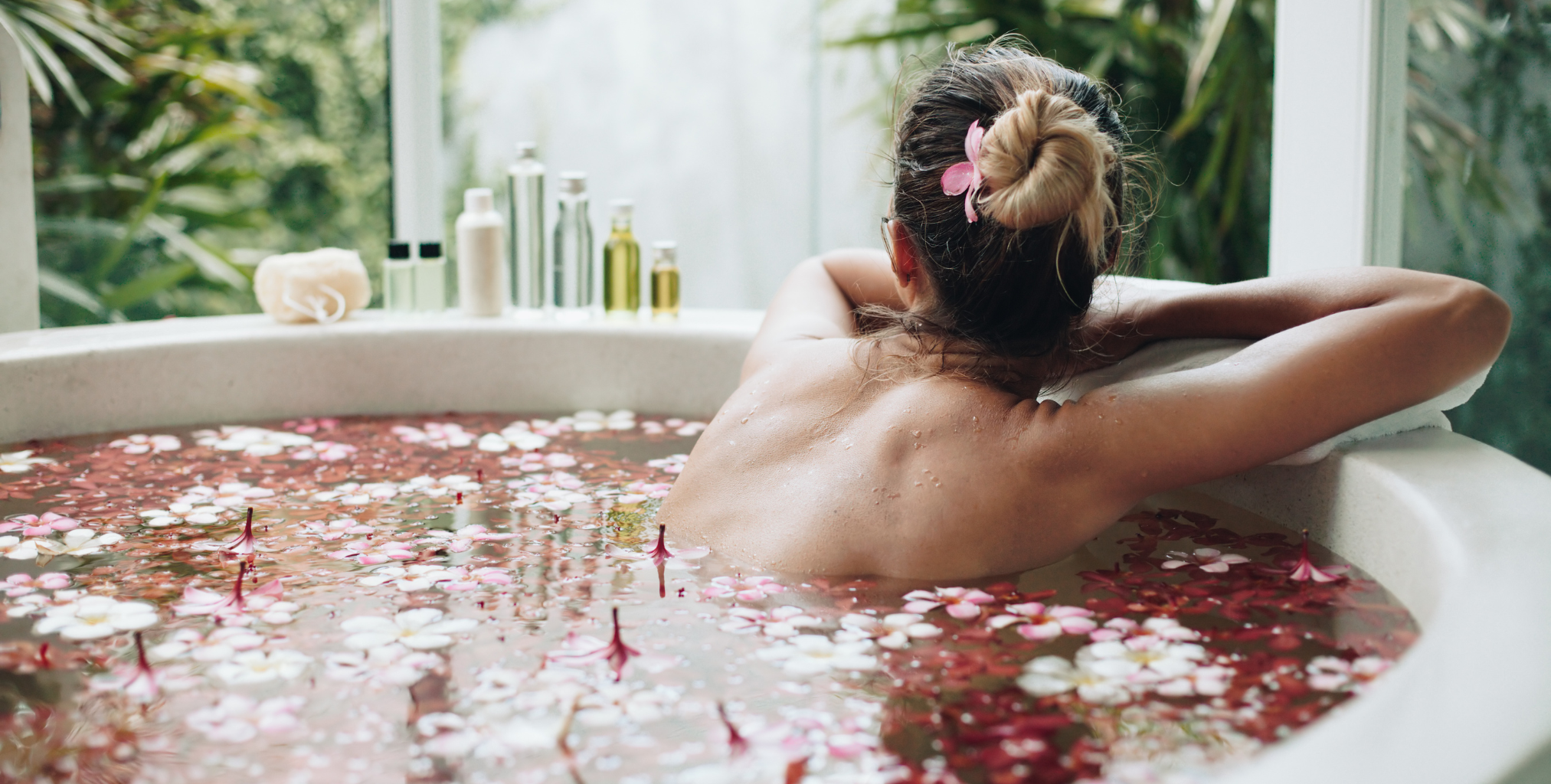 Frau in Badewanne mit Blüten